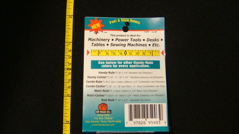 May include: A blue and white package of Peel & Stick Rulers. The package lists different types of rulers, including Handy-Rule, Handy-Center, Combi-Rule, Combi-Center, Metri-Rule, Metri-Center, and Rod-Rule. The package also includes the company name, SE Rose Co., and website address, www.handyrule.com.