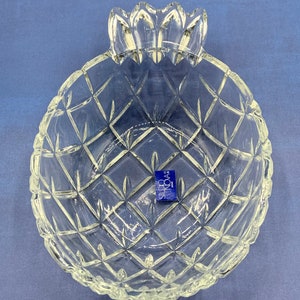 Könnte beinhalten: Eine durchsichtige Glasschale in Form einer Ananas mit einem Diamantenmuster. Die Schale hat einen blauen Aufkleber an der Seite, auf dem "Silvera" mit einem kleinen "R" in einem Kreis steht.