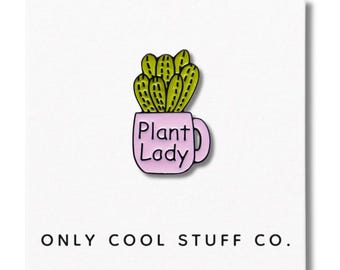 Puede incluir: Pin con un cactus verde en una taza rosa con la frase "Plant Lady". El pin está sobre un fondo blanco con el texto "ONLY COOL STUFF CO." en la parte inferior. El cactus tiene detalles amarillos.