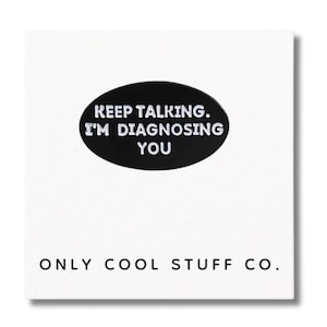 May include: A black oval pin with white text reading "KEEP TALKING. I'M DIAGNOSING YOU". The pin is on a white background, with the words "ONLY COOL STUFF CO." printed below in black.