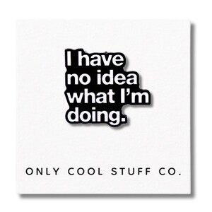 Può includere: Spilla smaltata in bianco e nero con la scritta "I have no idea what I'm doing." La spilla ha una forma a contorno nero. Le parole "ONLY COOL STUFF CO." sono stampate sotto su sfondo bianco.