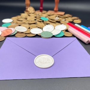 May include: A white wax seal with the initials "A1B" embossed on a purple envelope. The envelope is surrounded by a variety of gold, white, and green wax seals.