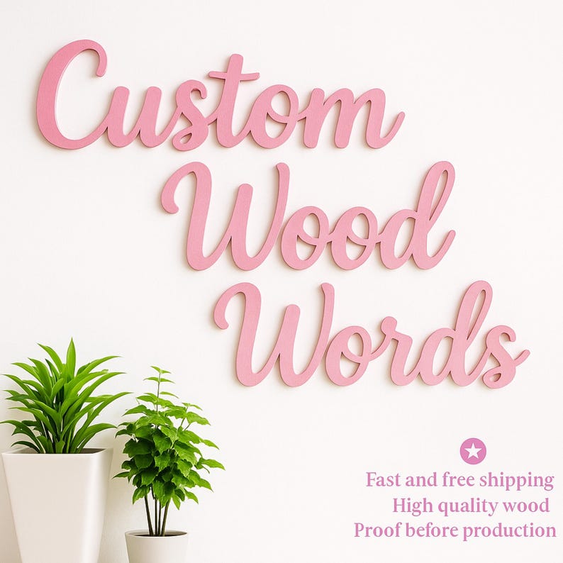 Op de afbeelding: Roze houten woorden die "Custom Wood Words" spellen in een cursief lettertype, gemonteerd op een witte muur. Twee groene planten in potten staan in de linkerbenedenhoek. De tekst "Fast and free shipping, High quality wood, Proof before production" staat rechtsonder.