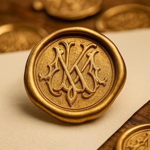 May include: A gold-colored wax seal with an ornate monogram of the letters 'NK'. The seal is round with a detailed design and is set against a neutral background. Other seals are visible in the background.