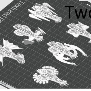 May include: A set of six white 3D printed spaceship models. The models are detailed and intricate, with a variety of shapes and sizes. The word "Two" is printed in black on a grey background.