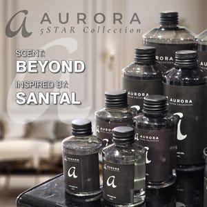 Puede incluir: Una colección de ocho botellas de vidrio negro con letras doradas. Las botellas están etiquetadas "Aurora 5 Star Collection" y contienen una fragancia llamada "Beyond" inspirada en "Santal".