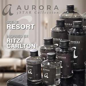 Könnte beinhalten: Eine Sammlung schwarzer Glasflaschen mit dem Text "AURORA 5STAR Collection" und "RESORT" auf den Etiketten. Die Flaschen sind mit einer klaren Flüssigkeit gefüllt und haben einen schwarzen Verschluss. Die Flaschen sind auf einer schwarzen Oberfläche angeordnet.