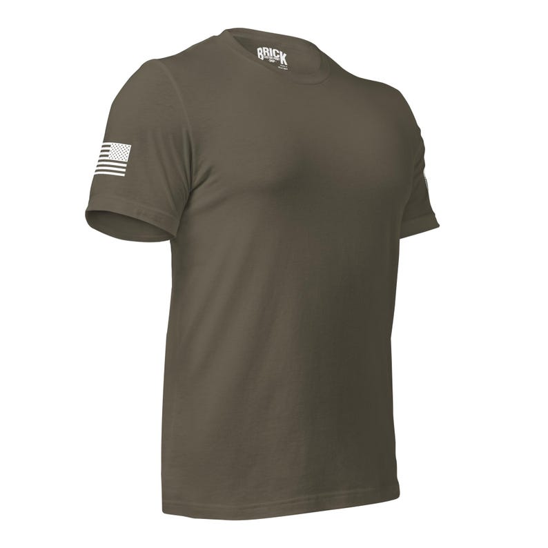 May include: A green short-sleeved t-shirt with a white American flag on the left sleeve and the word "BRICK" on the collar.