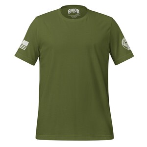 May include: A green short-sleeved t-shirt with a white American flag on the left sleeve and a white logo on the right sleeve. The logo says "Brick".