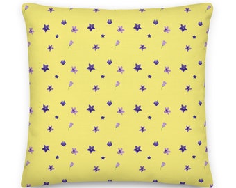 May include: A yellow throw pillow with a repeating pattern of purple flowers and stars.