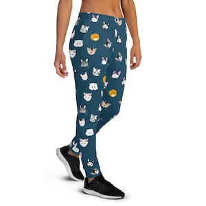 May include: Teal blue sweatpants with a repeating pattern of colorful cat faces.