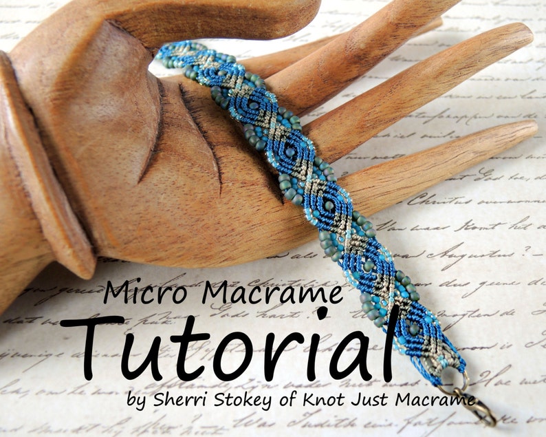 May include: A blue, green, and silver micro macrame bracelet with a clasp closure. The bracelet is on a wooden hand model. The text "Micro Macrame Tutorial by Sherri Stokey of Knot Just Macrame" is below the bracelet.