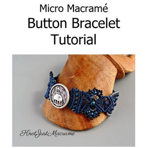 May include: A close-up of a blue and silver macrame bracelet with a button featuring an elephant design. The bracelet is on a wooden display stand. The text "Knot Just Macrame" is visible below the bracelet.