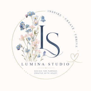 May include: A circular logo design featuring a watercolor illustration of blue and pink wildflowers next to the dark blue letters LS. The text reads INSPIRE CREATE THRIVE, LUMINA STUDIO, and DESIGN FOR PURPOSE. CREATED WITH HEART. A gold line forms a circle.