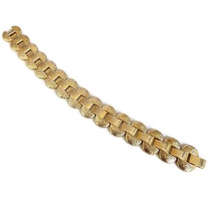 K&ouml;nnte beinhalten: Ein goldfarbenes Armband mit einem Kettenglieddesign mit runden, strukturierten Gliedern.