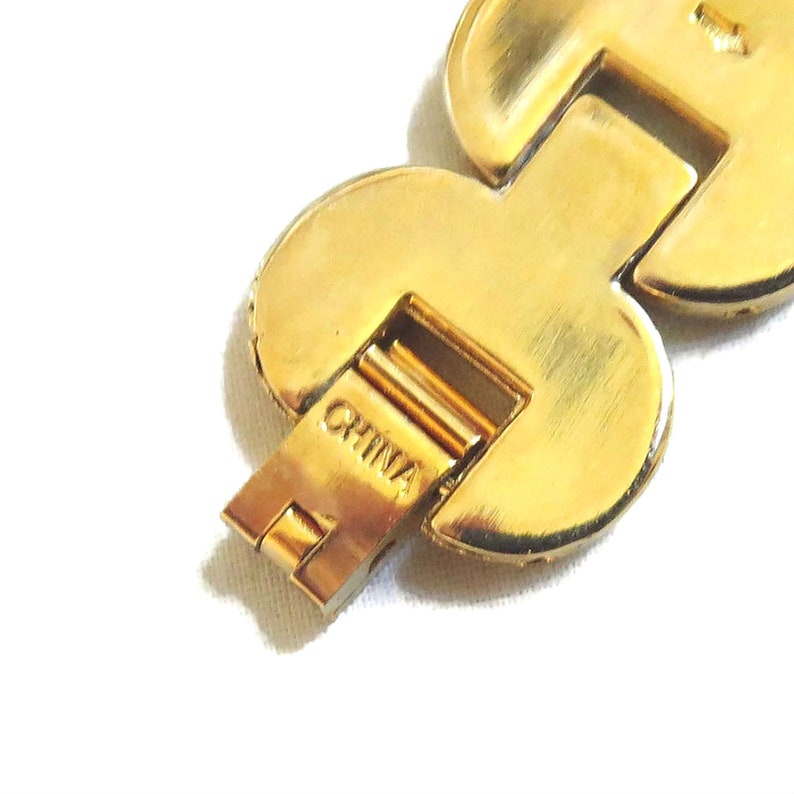 K&ouml;nnte beinhalten: Goldfarbenes Armband mit herzf&ouml;rmigem Design und einem Verschluss mit der Aufschrift "CHINA".