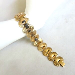 K&ouml;nnte beinhalten: Ein goldfarbenes Armband mit einem Kettenglieddesign mit runden, strukturierten Gliedern. Das Armband ist aus Metall und hat eine polierte Oberfl&auml;che.