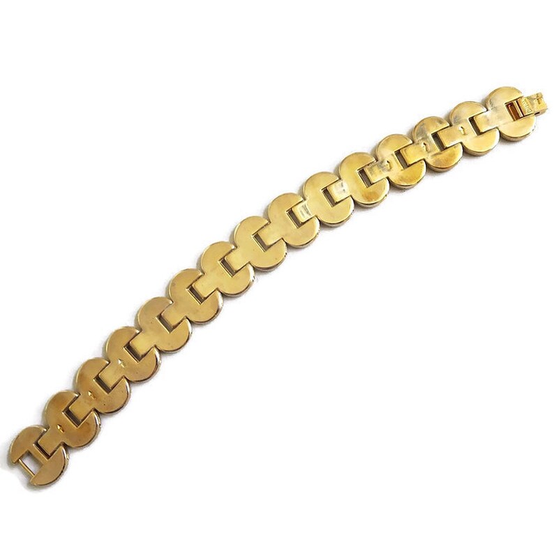 K&ouml;nnte beinhalten: Ein goldfarbenes Armband mit einem Kettenglieddesign. Jedes Glied hat eine abgerundete quadratische Form.