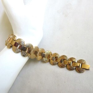 K&ouml;nnte beinhalten: Ein goldfarbenes Armband mit einem Kettenglieddesign mit runden, strukturierten Gliedern.