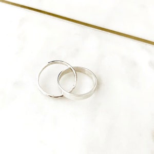 May include: Two silver rings interlocked, one with a hammered finish and the other with a smooth surface.