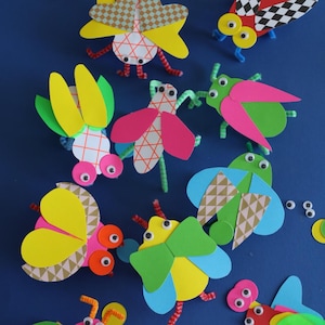 May include: A collection of colourful paper bugs with googly eyes and pipe cleaner legs. The bugs are made from patterned paper and have different shapes and sizes.