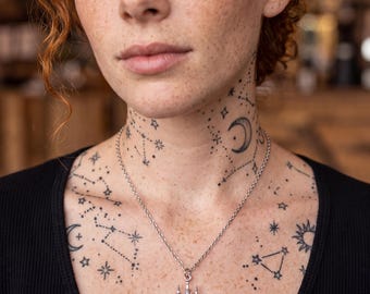 Può includere: Una collana in metallo color argento con un ciondolo a forma di piccolo lampadario decorato, con tre pietre trasparenti sfaccettate a forma di pera che pendono dalla base, fissata a una semplice e sottile catena a maglie.