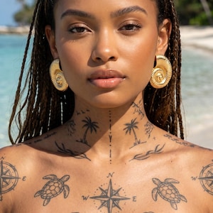 May include: Gold-coloured, spiral-shaped earrings. The earrings are large and have a detailed, textured surface. The image shows a person with braided hair and tattoos on the chest and neck, with a beach background.