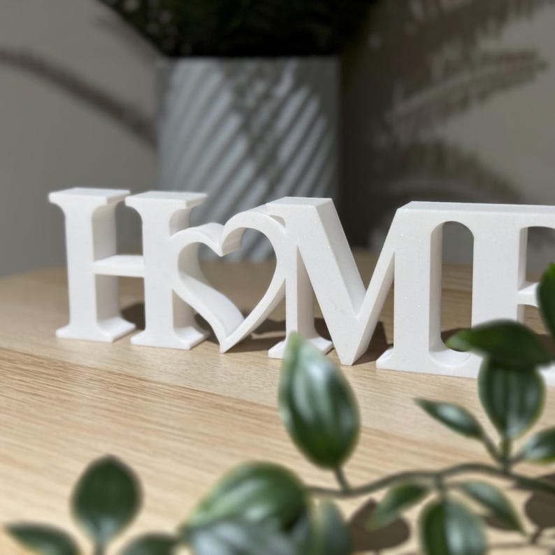 Close-up front view of 3D printed white HOME sign with heart showing crisp lettering and clean finish