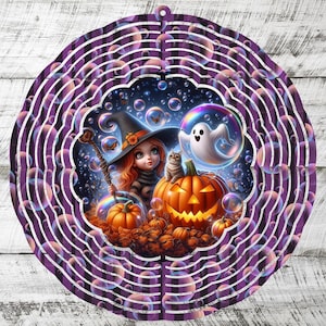 May include: A circular metal wind spinner featuring a purple and black plaid pattern with a central illustration of a witch, a cat, a ghost, and jack-o'-lanterns surrounded by floating bubbles and butterflies against a dark night sky background.
