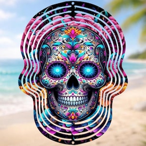 May include: A colorful, decorative skull design with intricate floral patterns and glowing blue eyes. The skull is surrounded by layered, curved lines and floral accents in shades of pink, purple, and teal. The background shows a beach scene.