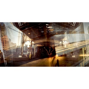 May include: A panoramic view of a city street with tall buildings reflected in the windows of a tunnel. The tunnel is dark and shadowy, with a single figure walking through it. The image is a double exposure, with the city buildings superimposed over the tunnel.