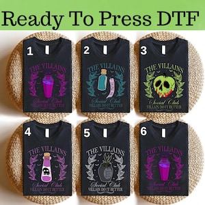 May include: Six black t-shirts with different designs featuring the text "The Villains Social Club". Each shirt has a unique graphic of a potion bottle, a poison apple, or a plant, with the phrase "Villain Do It Better".