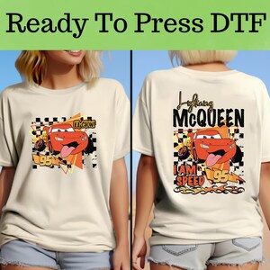 Puede incluir: Camisetas color crema con una imagen de dibujos animados de Rayo McQueen de la pel&iacute;cula Cars. La parte delantera de la camiseta tiene el texto "Ka-Chow!" y el n&uacute;mero 95. La parte trasera de la camiseta dice "Lightning McQueen" y "I am speed".