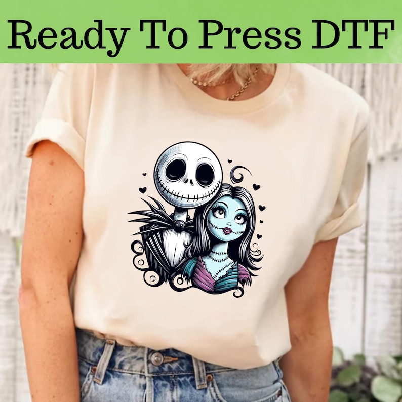 Peut inclure: Un t-shirt blanc avec un imprim&eacute; graphique de Jack Skellington et Sally du film L'&Eacute;trange No&euml;l de monsieur Jack. Le graphique est en noir, blanc, bleu et violet.