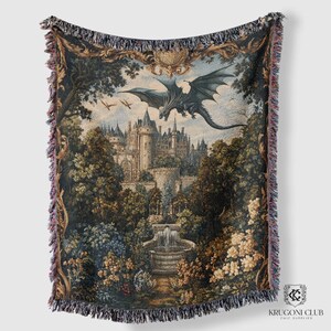 May include: Woven tapestry throw blanket featuring a fantasy landscape with a castle, fountain, and a dragon in flight. The artwork is framed by a decorative border and finished with fringed edges. The color palette includes shades of blue, green, and beige.