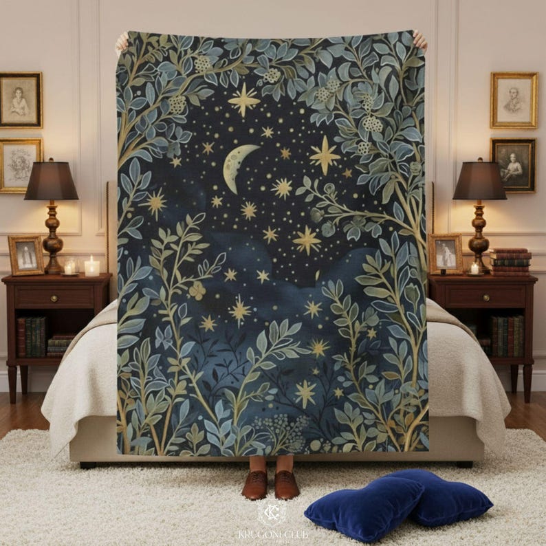 Celestial moon and stars fleece minky blanket held up by person on elegant bed showing full design with botanical sage green foliage border, crescent moon and golden stars on dark navy blue background, size comparison demonstration for witchy boho bedroom tapestry decor