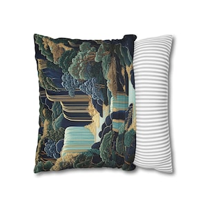 May include: Square throw pillow with a digitally created landscape design. The pillow features a dark blue background with gold, green, and teal accents. A second pillow with gray and white stripes is partially visible.