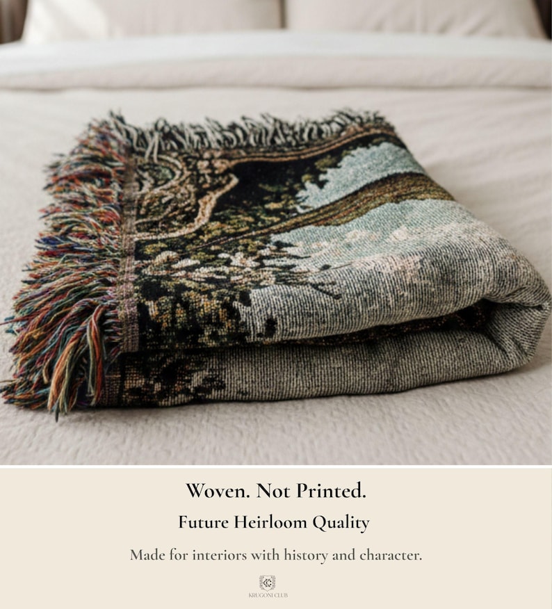 Pode incluir: Uma manta tecida dobrada com uma cena de paisagem detalhada em tons de verde escuro, preto e azul claro. A manta tem uma borda com franjas de fios multicoloridos. O texto na imagem diz: Woven. Not Printed. Future Heirloom Quality. Made for interiors with history and character.