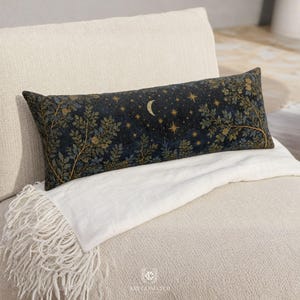 May include: A rectangular lumbar pillow featuring a dark navy blue fabric with a gold celestial pattern of a crescent moon and stars, accented by intricate gold and dark green botanical foliage designs across the entire surface.
