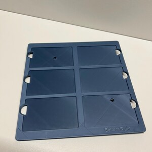 May include: A blue plastic card holder with six slots for cards. The holder has a textured surface and the words "Bottom Right" are printed on the bottom right corner.
