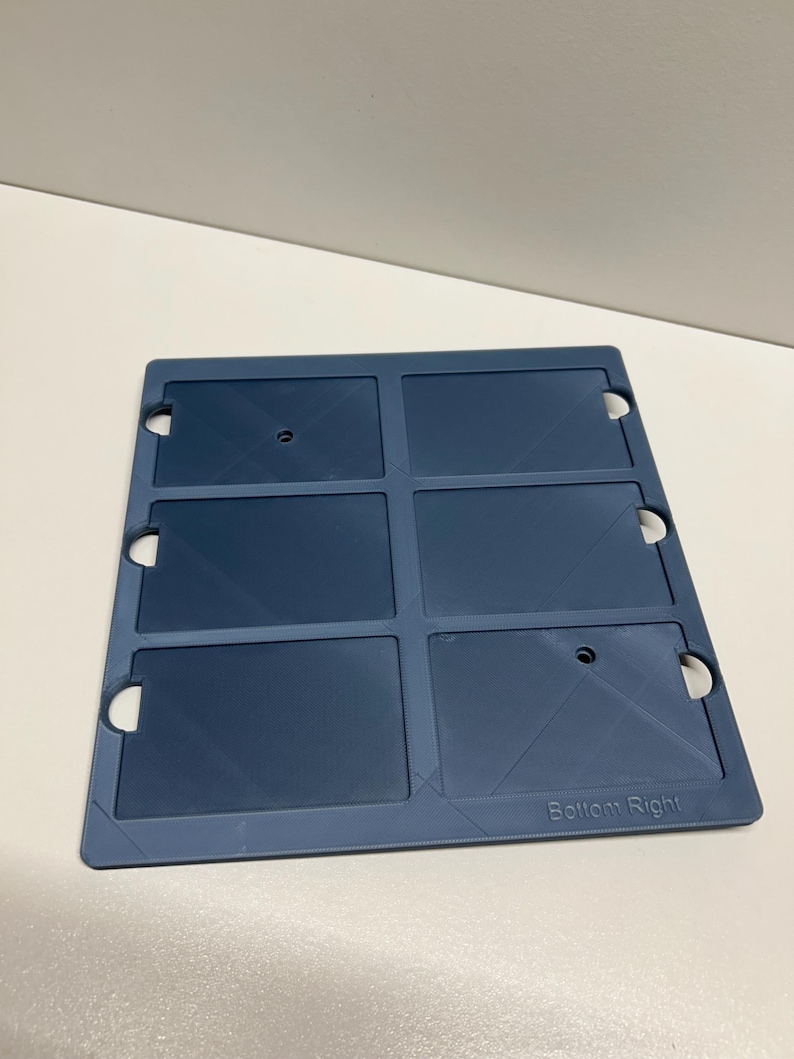 May include: A blue plastic card holder with six slots for cards. The holder has a textured surface and the words "Bottom Right" are printed on the bottom right corner.