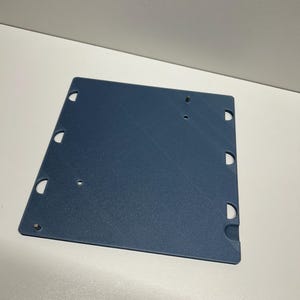 May include: A blue plastic sheet with multiple holes around the edges. The sheet is textured and has a slightly rough surface.