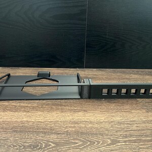 Può includere: Un rack in metallo nero con sei slot per il montaggio di apparecchiature. Il rack è progettato per l'uso in un rack di server o altre applicazioni simili.