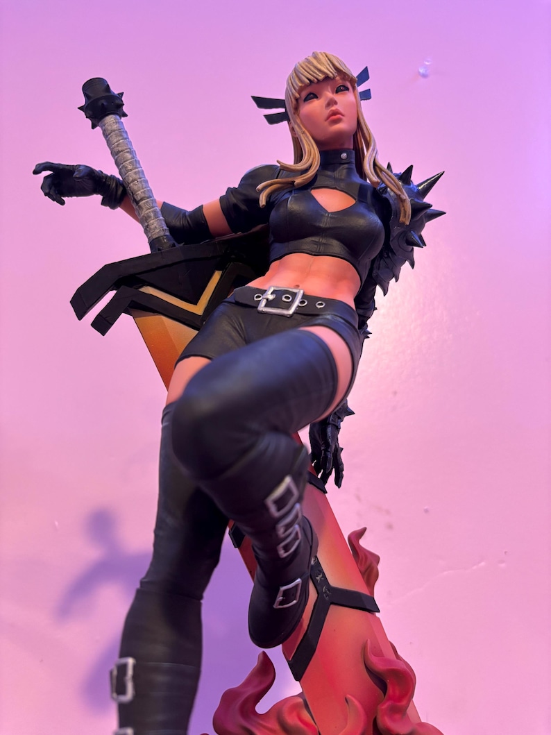 May include: A detailed statue of a female character in a black outfit, holding a large sword. The figure has blonde hair and is posed dynamically. The sword has a yellow blade and black handle. The statue is set against a pink background.