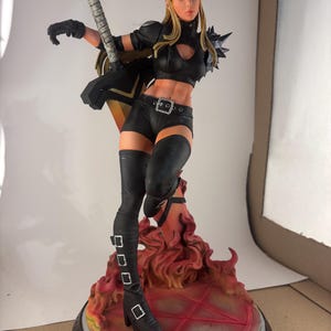 May include: A detailed figurine of a female character in a dynamic pose, holding a stylized weapon. She wears a black outfit with thigh-high boots and a belt. The base features a fiery design with a red pentagram and the X-Men logo.