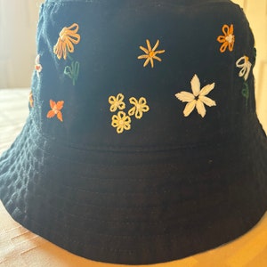 black hand embroidered bucket hat, cotton, embroidered flower hat with signature lazy daisy flower on the back.