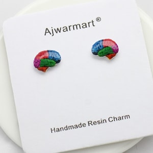 May include: A pair of handmade resin charm earrings shaped like colorful brains. The earrings are displayed on a white card with the text "Ajwarmart" and "Handmade Resin Charm". The brain-shaped earrings are painted in shades of blue, red, green, orange, and purple.