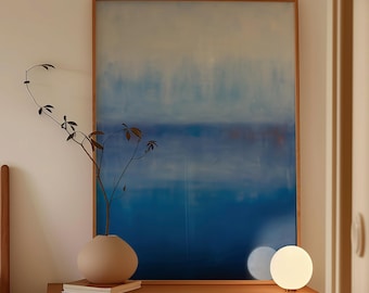 May include: A bedroom interior with a wooden cabinet, a beige vase with greenery, and a large abstract painting in blue and white. A small, spherical lamp emits a soft glow. The painting is framed in wood, and the room has a minimalist aesthetic.