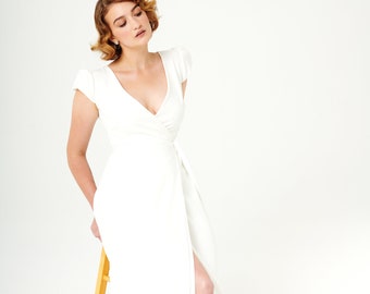 Femme Fatale Minimalist and comfortable wrap wedding dress with pleated architectural cap sleeves. (Femme Fatale)