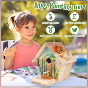 May include: A wooden birdhouse with a painted design of birds and trees. The birdhouse has a small perch and a circular entrance. The text "Enjoy Painting Time" is visible above the birdhouse. A young person is holding a paintbrush.
